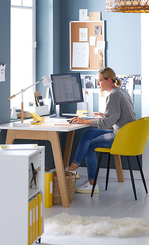 Woman in home office with desk and yellow chair